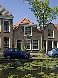 Woonhuis, in 1824 voor geweermaker Reinier van Vuuren gebouwd in een traditionele bouwtrant op een ledig erf op de oosthoek van een poort genaamd ¿Oude Kost¿.