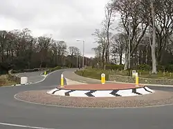 De rotonde bij Governor's Bridge. De coureurs gebruiken de hoofdweg niet, maar komen uit het parallelweggetje en draaien scherp rechts via "Governor's Dip". De witte stenen kolom heeft altijd in de bocht gestaan, maar het origineel werd in de jaren nul door een vrachtwagenchauffeur omver gereden. Enkele jaren lang werd de weg door strobalen gemarkeerd, maar omdat de kolom "historische waarde" voor de TT had werd een replica geplaatst