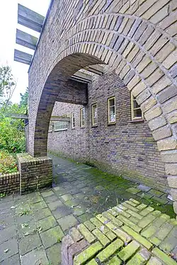 Bakstenen poort naar terras langs Pioenvijver