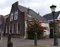 Pand met brede tuitgevel op de hoek van het kerkplein