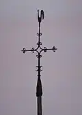 IJzeren hagelkruis met bekronende haan op een houten staak