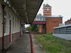 Het stationsgebouw met klokkentoren uit 1912 achter het opgebroken spoor van de Stanmoretak.
