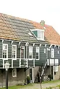 Houten huis onder een dak met de nummers 8 en 10