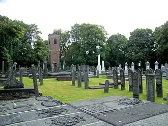 Zicht op de begraafplaats met klokkentoren