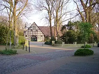 Hof Holling, een van de oudste herenboerderijen van Hopsten. Links een monument voor de Tödden.