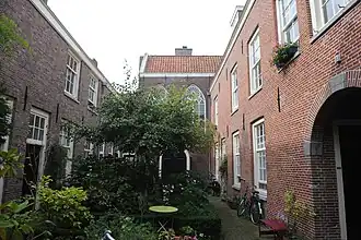 Hofje De Zeven Keurvorsten, rechts de huisjes uit circa 1645, links de 7 huisjes uit 1724, op de achtergrond de oude kapel