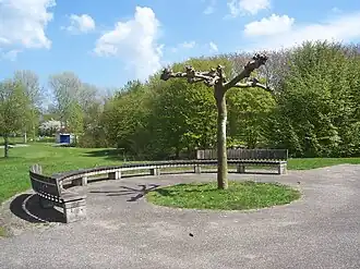 Hofje met speeltafels. Gaasperpark (voormalige Floriade). Deze ronde bank sluit het geheel af. Jaartal en maker(s) onbekend.