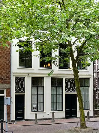 Het Compas, een pand met in oorsprong bedrijfsruimte, twee woonlagen en een kapverdieping onder samenstel van pannen zadeldaken tussen puntgevels