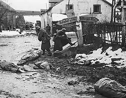 Duitsers trekken te Honsfeld de laarzen aan van gedode G.I.'s