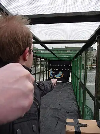 Een deelnemer op de met netten en gaas afgeschermde schietbaan