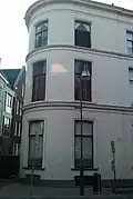 Pand, dat de afrondende linkerhoek vormt van een in het derde kwart van de 19e eeuw als een symmetrisch geheel ontworpen straatwand