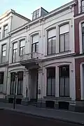 Pand dat deel uitmaakt van een in het derde kwart van de 19e eeuw als een symmetrisch geheel ontworpen straatwand