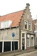 Huis met trapgevel bekroond door een gebogen fronton