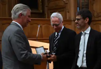 Koning Filip van België overhandigt de prijs aan enkele laureaten