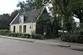 Houten huis met zadeldak, evenwijdig aan de straat