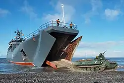 Een MT-LB-rupsvoertuig rijdt uit het landingsvaartuig Aleksandr Otrakovski tijdens een militaire oefening waarbij gemotoriseerde infantristen een bezetting van het vliegveld van Temp simuleerden (2017)