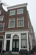 Pand met bakstenen gevel met rechte kroonlijst. Onderpui met houten pilasterstelling, zijgevel zijde Herengracht met deur en deuromlijsting. Onderpui 19e eeuw. Gerestaureerd 1940