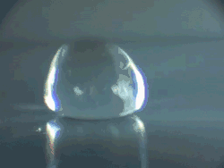 Animatie: Een druppel stuitert op een hete plaat, kennelijk net onder het leidenfrost-punt