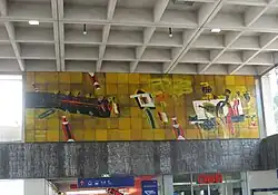 Zuidwand van de stationshal met de wandschildering tussen fries en plafond.