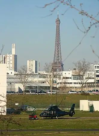 Een SA365 Dauphin op de heliport van Issy met de Eiffeltoren op de achtergrond