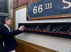 Een braille-indicatie van het metroroutenetwerk is zichtbaar op een verhoogd reliëfbord op station 66 St–Lincoln Center, aangebracht als onderdeel van nieuwe wayfinding-maatregelen voor toegankelijkheid binnen het MTA-systeem.