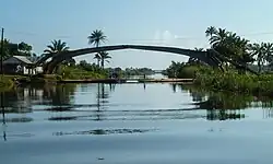 Door een cycloon verwoeste brug bij Mananjary. Eronder is een provisorische bamboebrug aangelegd, die tegen betaling wordt geopend voor schepen.