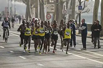 Peter Some (in geel shirt uiterst links) tijdens de marathon van Parijs in 2013.
