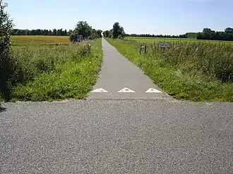 Het fietspad over de voormalige spoorlijn. Achter het geboomte lag de halte Velds.
