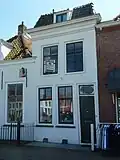 Huis met geverfde lijstgevel. Gebroken kap