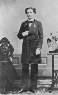 Een zwart-witfoto van Mary Edwards Walker in een pak, staande met haar rechterhand in haar jasje, terwijl ze naar de camera kijkt.