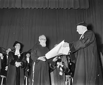 Michels reikt Nijmeegs eredoctoraat uit aan pater Maximilianus OFM Cap (=Petrus van Dun) (1958)