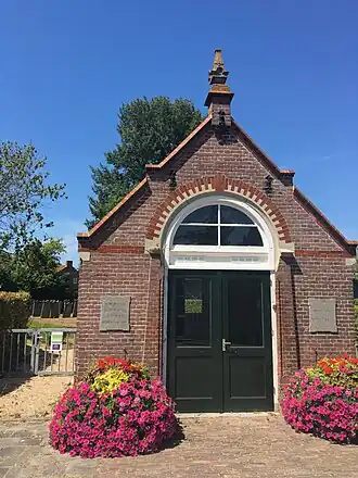 Ingang van de nieuwe joodse begraafgplaats. Op de achtergrond zijn er graven te zien.