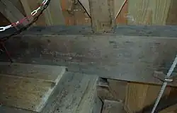 Steenlijst met inscriptie:Van Boom Naar Balk BezaagdWeth. AJJ. v. d. Heiden 13-2-1992