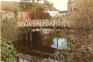 Cementrustieke brug over slotgracht van het kasteel in Chazelet