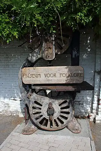 Attribuut bij de ingang (lintzaag uit het atelier van serrebouwer Omer Van Lierde)