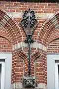 Detail van een Dordtse gevel met muuranker en gebeeldhouwd kopje