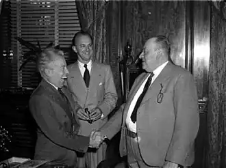 De burgemeester van Montreal, Camillien Houde (r), schudt de hand van Desiré Defauw (l) terwijl de impresario Peter Béique toekijkt (m)