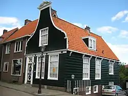 Nieuwendammerdijk 359 met een 19de-eeuwse klokgevel en onderpui met fries in empirestijl