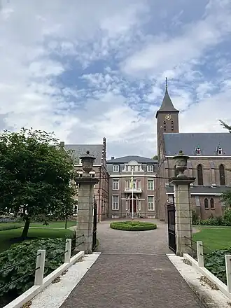 De hekpijlers uit begin 18e eeuw en op de achtergrond (in het midden) de havezate uit 1863-1864