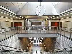 De verdeelhal met de roltrappen naar het perron en de deuren naar de fietsenstallingen.