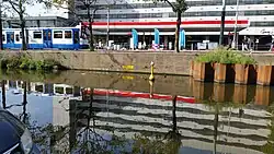 In het midden: OKAY; een combinatie van letters uit een scrabblespel (met letterwaarden) en een bord dat aangeeft dat hier een kabel loopt (K) (augustus 2019)