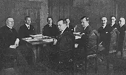 18 december, enkele dagen voor de ondertekening. Van links af:  Johan Ludwig Mowinckel (Noorwegen, politicus, initiatiefnemer); Rolf Andvord (Noorwegen, delegatieleider); Christian Günther (Zweden, delegatieleider); Jan (Noorwegen, onderhandelaar); J.A. Nederbragt (Nederland, onderhandelaar); Rolf Andersen (Noorwegen, secretaris van de legatie); M. Suetens (België, onderhandelaar); Waerum (Denemarken, delegatieleider); Clan (Denemarken, kamerheer).