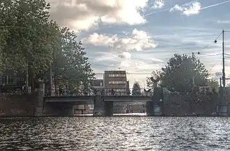 De brug gezien naar het oosten, met links achter het struweel het Hoofdbureau van Politie