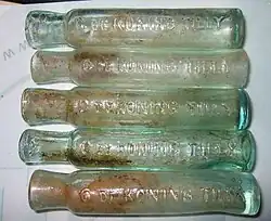 Olieflesjes met het opschrift C. de Koning Tilly