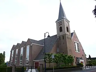 De kerk van enige afstand, duidelijk te zien is de uitbreiding van 1990