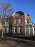 Woonhuis, in opdracht van S. Menko jr. in 1909 naar een ontwerp van de bouwkundige R. van der Woerd (Enschede) gebouwd op de hoek van de Prinsenstraat, M.H. Tromplaan.