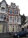 Hoekpand Reinkenstraat in neorenaissance trant. Pand met afgeschuinde hoek en trapgevels, gedateerd op cartouches. Versiering van banden, blokken en ontlastingsbogen. Erker op de hoek op ijzeren draagconstructie