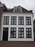 Huis met witgepleisterde gevel en kroonlijstgoot