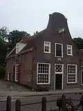 Huis met halsgevel. Voormalige bakkerswinkel. Gerestaureerd