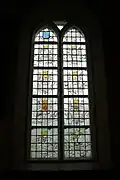 Gebrandschilderd glas in de kerk van Sint-Agathakerk van Oudega. Links het tweede van boven toont het wapen van Van Glinstra.